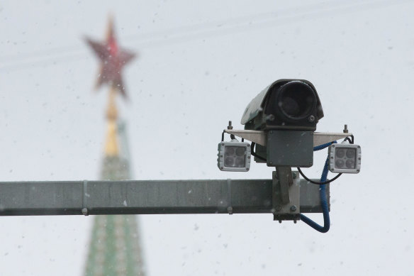 A surveillance camera operates as the Spasskaya tower of the Kremlin stands beyond in Moscow, Russia.