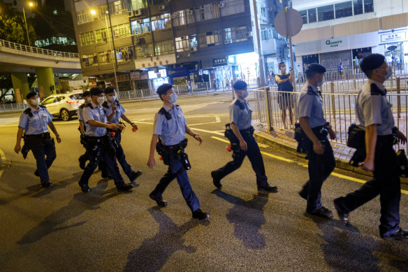 Police officers cross a road near Victoria Park, the traditional site of the annual Tiananmen candlelight vigil in Hong Kong.