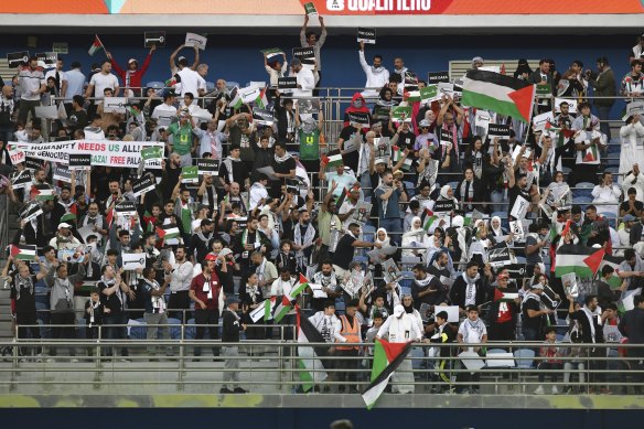 Fans wave Palestine national flags and hold pro-Palestinian banners during the match between Palestine and Australia.