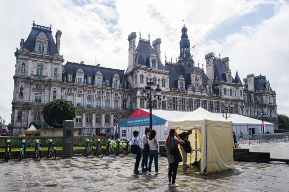 People register for COVID-19 vaccinations at tents outside the Hotel de Ville, the Paris Mayor’s office, on Monday.