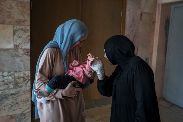Two women look at a young baby as patients are seen inside of Jabal Amel Hospital, where an Israeli airstrike left a result of at least 4 people killed and 127 injured, on June 2, 2026 in Tyre, Lebanon. Israeli military airstrikes have repeatedly struck areas immediately adjacent to major hospitals in Tyre, Southern Lebanon, causing severe structural damage and wounding multiple healthcare workers. While the Lebanese Ministry of Public Health and hospital officials condemn these actions as systematic attacks on healthcare infrastructure, the Israel Defense Forces (IDF) state that their operations strictly target nearby Hezbollah command centres, weapons depots, and operational facilities.