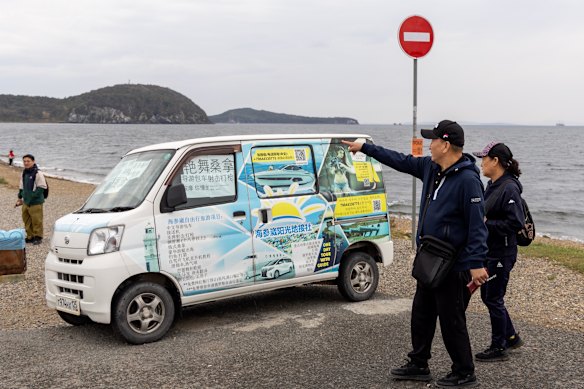 A minivan in Vladivostok displays Chinese advertisements for adult entertainment and other services in the city.