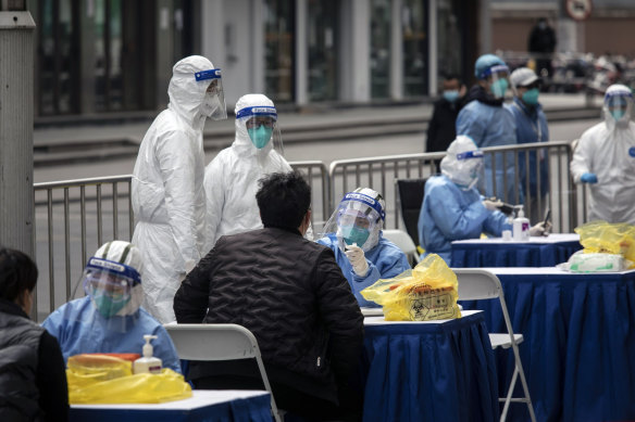 Health workers test for COVID at a clothing market in Shanghai on March 10, 2022. 