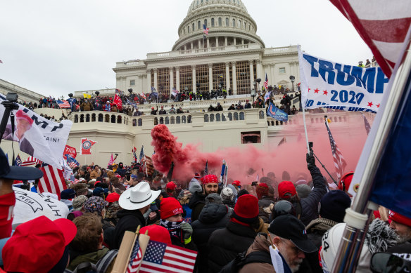 A demonstrator unleashes a smoke grenade in front of the US Capitol building on January 6.