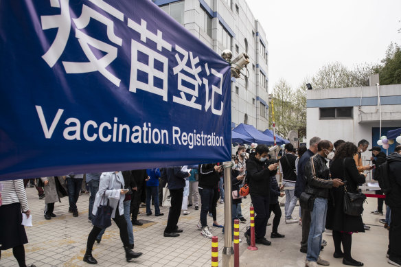People wait outside a COVID-19 vaccination center for foreign nationals in Shanghai, China.