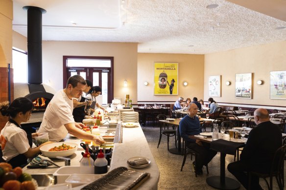 An open kitchen and a vintage film poster add colour and movement to the Puttanesca dining room.