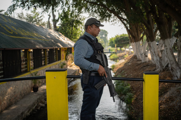 An armed man guards the restaurant where candidate Willy Ochoa eats.
