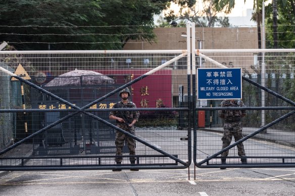 Members of the PLA stand guard at an entrance to their barracks in the Kowloon Tong area of Hong Kong. 