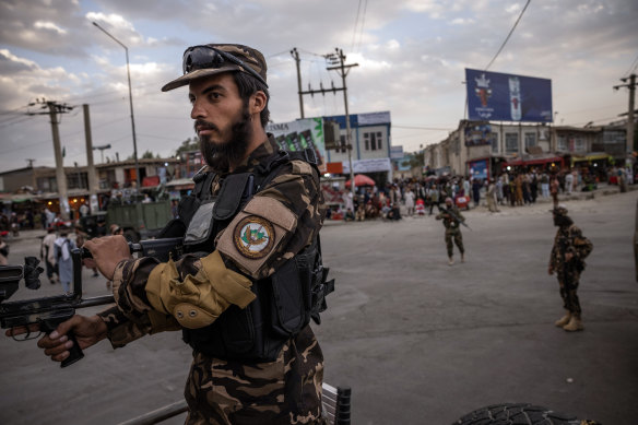 Taliban fighters control their positions near the entrance to the airport in Kabul on Monday.