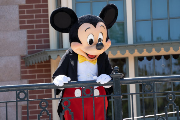 A performer dressed as Mickey Mouse entertains guests during the reopening of the Disneyland theme park in Anaheim. The usual hugs and close selfies with characters are not allowed though.