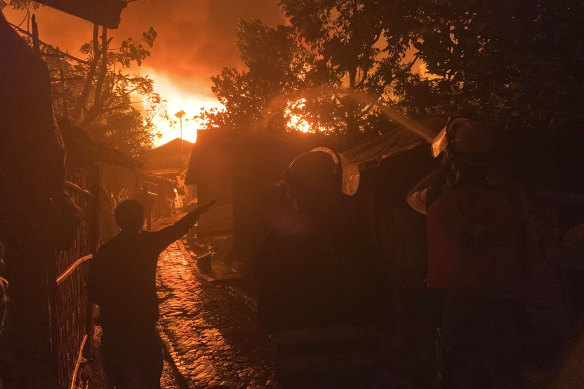 Firefighters work to douse flames at a refugee camp at Kutupalong in Cox’s Bazar district, Bangladesh, on Sunday.