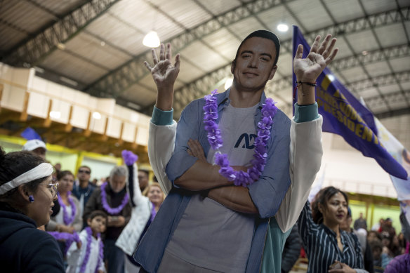 A supporter plays with a cardboard cutout of Daniel Noboa as she celebrates the early election results in Quito, Ecuador.