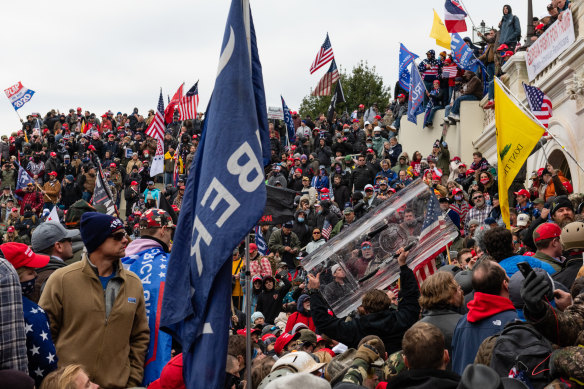 Rioters steal a DC Metropolitan Police shield outside the US Capitol building.