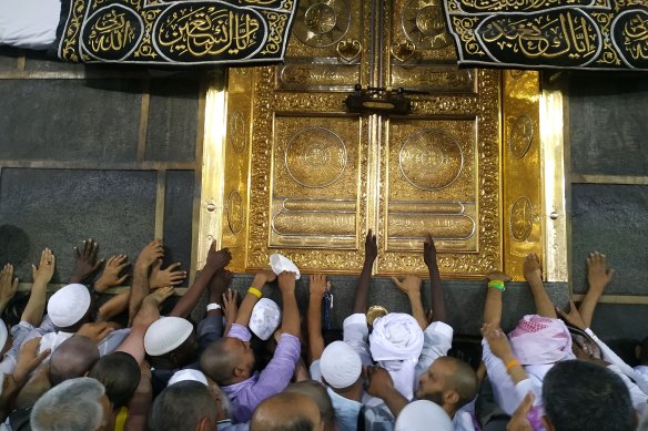 Pilgrims touch the Kaaba, which they believe to be the first mosque.