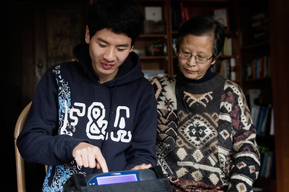 Tim Chan uses an electronic voice-output device, with his mother Sarah Chan, in 2014.