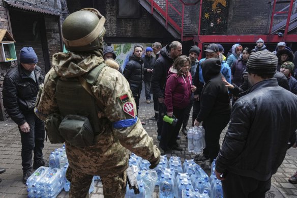 Ukrainian servicemen distribute water to people in Mariupol.