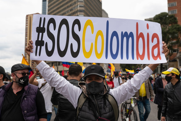 A demonstrator holds a banner during a protest against the government’s tax reforms in Bogota, Colombia.