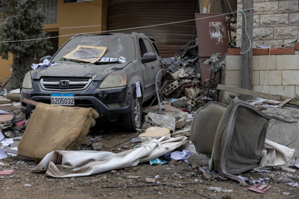 Debris covers a damaged vehicle and the ground after a overnight Israeli airstrike in Qmatiyeh, Lebanon.