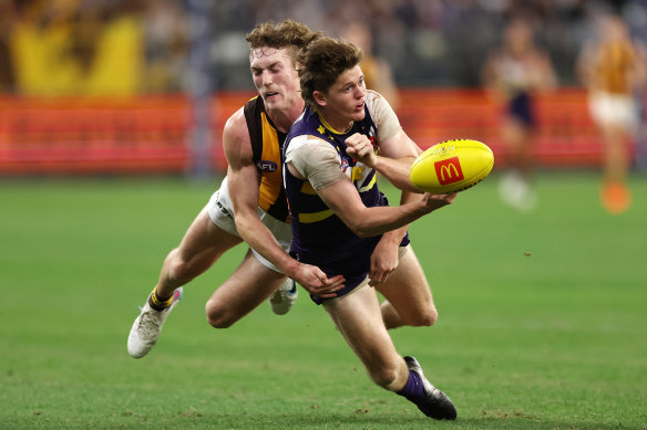 Nathan O’Driscoll of the Dockers  handpasses the ball under pressure from Jack Scrimshaw.