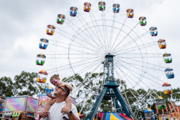 Lola, 2, rests on her father Guy Power’s shoulders, happy with food and facepaint. 