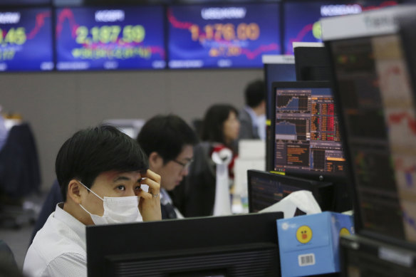 A currency trader watches monitors at the foreign exchange dealing room of a bank in Seoul, South Korea.
