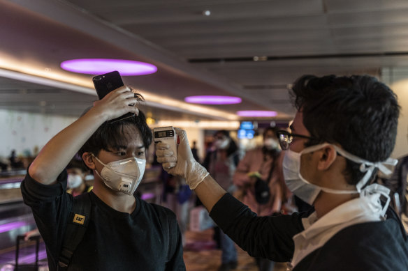 An arriving passenger has his temperature checked at Changi Airport, Singapore. 