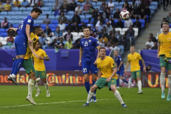 Uzbekistan’s Azizbek Turgunboev heads to score against the Socceroos.