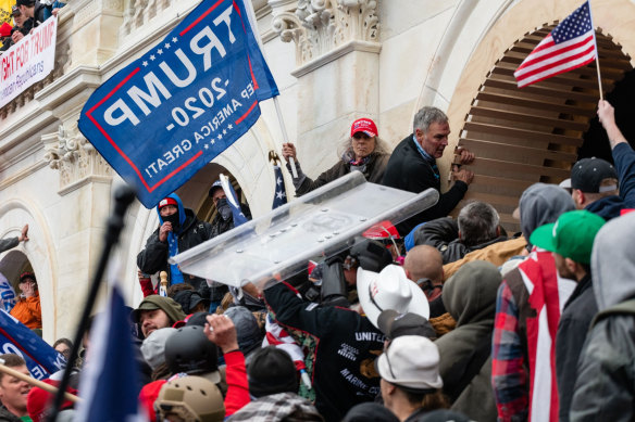 Demonstrators steal a Metropolitan Police riot shield while attempting to enter the US Capitol building during the riot in Washington, DC.