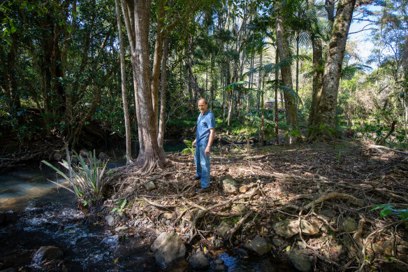 Patrick Tatam inspects the creek which broke its banks at the edge of his property in February.