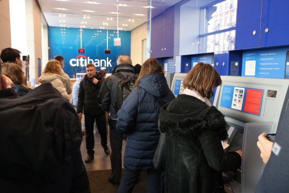 Russian customers queue at a Citibank ATM in Moscow to withdraw their cash. 