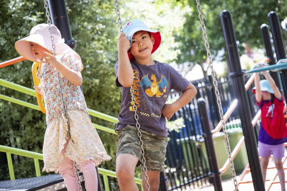 Kaiden Tee, 7, with friend Elyna-Rose Zheng, 4, at the Camp Australia holiday program at Abbotsford Primary School on Thursday.
