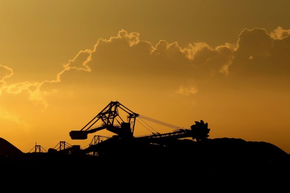 An excavator at a working coal mine at sunset.