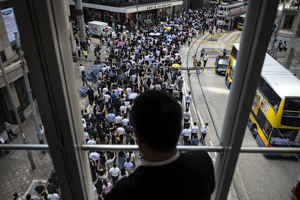 A man watches the growing protest on Friday from a pedestrian footbridge in Hong Kong's Central district.