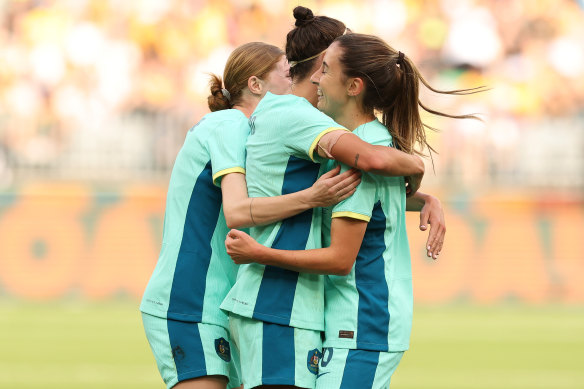 Cortnee Vine and Caitlin Foord celebrate with Clare Wheeler after she scores her first-ever goal for the Matildas.