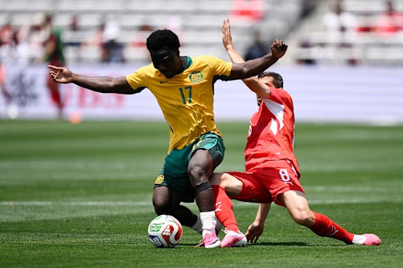 Nestory Irankunda of Australia competes for the ball against Remo Freuler of Switzerland.