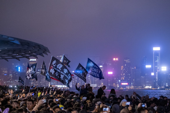 Demonstrators wave flags as they gather for a New Year's Eve countdown event in the Tsim Sha Tsui district of Hong Kong.