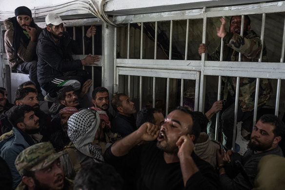 Syrians clamber to enter Sednaya.