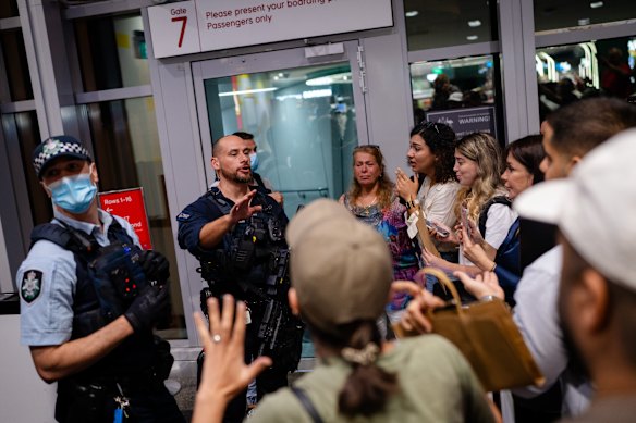 Police attempt to defuse tensions as supporters watch the arrival of the Lionesses soccer team at Sydney International Airport.