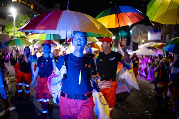 NSW State Emergency Service workers march with rainbow umbrellas.