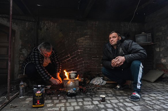 Men cook a meal in a yard in Mariupol, Ukraine, Sunday, March 6, 2022.