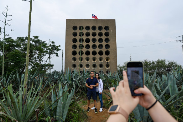 A woman takes pictures of her parents in front of the Beishan Broadcasting Wall in Kinmen, which boomed messages inviting Chinese soldiers to defect to Taiwan.