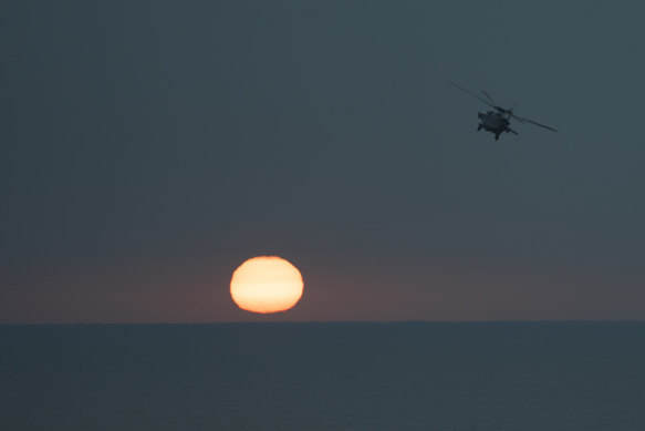 An MH-60S Seahawk helicopter flies back to the USS aircraft carrier Dwight D. Eisenhower.