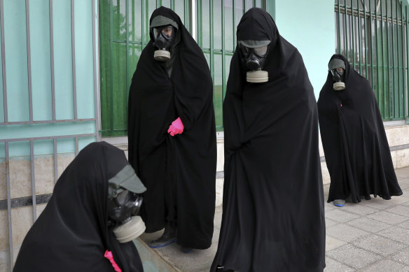 Women wearing protective clothing and chadors arrive at a cemetery in Ghaemshahr, Iran, to prepare the body of a person who died from COVID-19. 