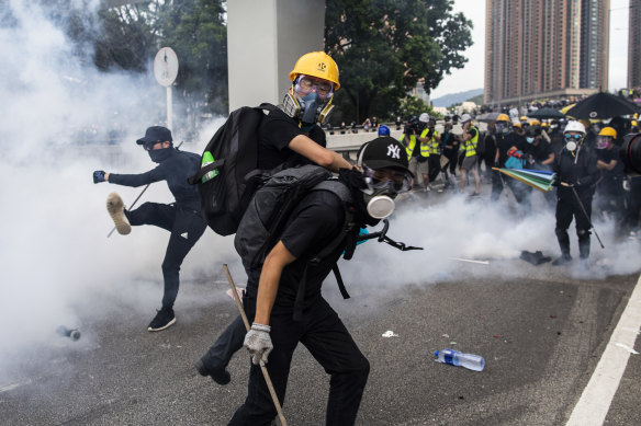 Demonstrators stand in a cloud of tear gas during a protest in Yuen Long. 
