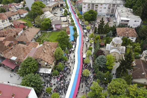 People hold a giant Serbian flag during a protest in the town of Zvecan, northern Kosovo, on May 31, against new Albanian mayors.