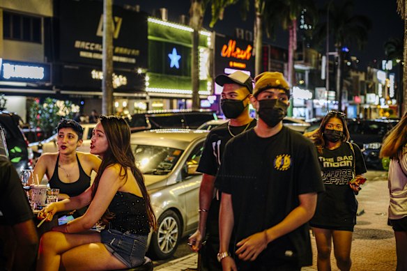 Pedestrians pass customers seated outdoors at a bar in the Bangsar district of Kuala Lumpur late last month.