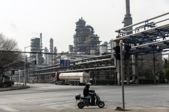 A motorcyclist rides past a petrochemical production complex on the outskirts of Shanghai. China, the world’s second-largest economy, has become addicted to foreign oil at a stunning pace.