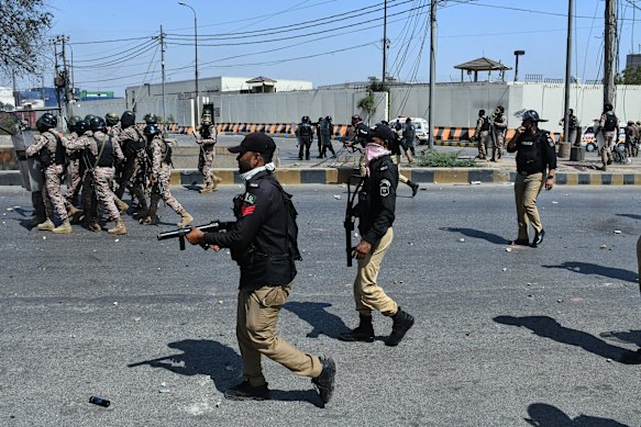 Paramilitary soldiers and police officers chase Shiite Muslims throwing stones toward them during the Karachi protests.