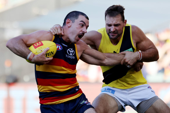 Looking to evade: Taylor Walker is tackled by Toby Nankervis.