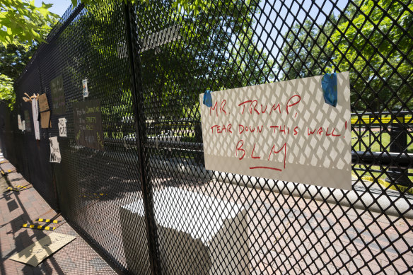 Signs left by demonstrators are taped to the perimeter fencing outside the White House in Washington on Sunday.